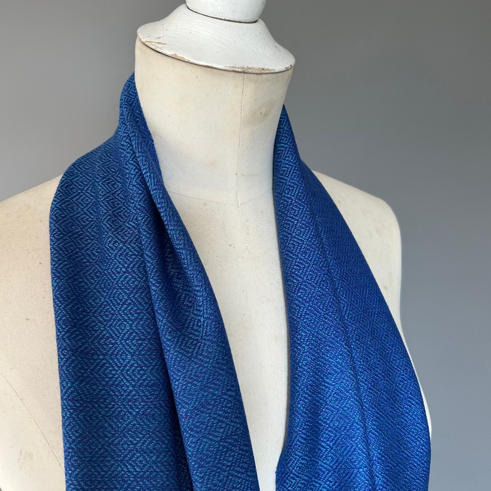 Blue scarf on a mannequin against a gray background