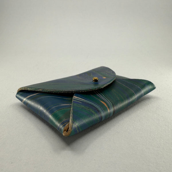 Looking at the angled right side and base of the purse. 