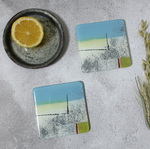 Summer Breeze Coaster set by Jenny Hoole. An abstract painterly seaside scene in blue and soft grey with soft yellow highlights 10 x 10cm