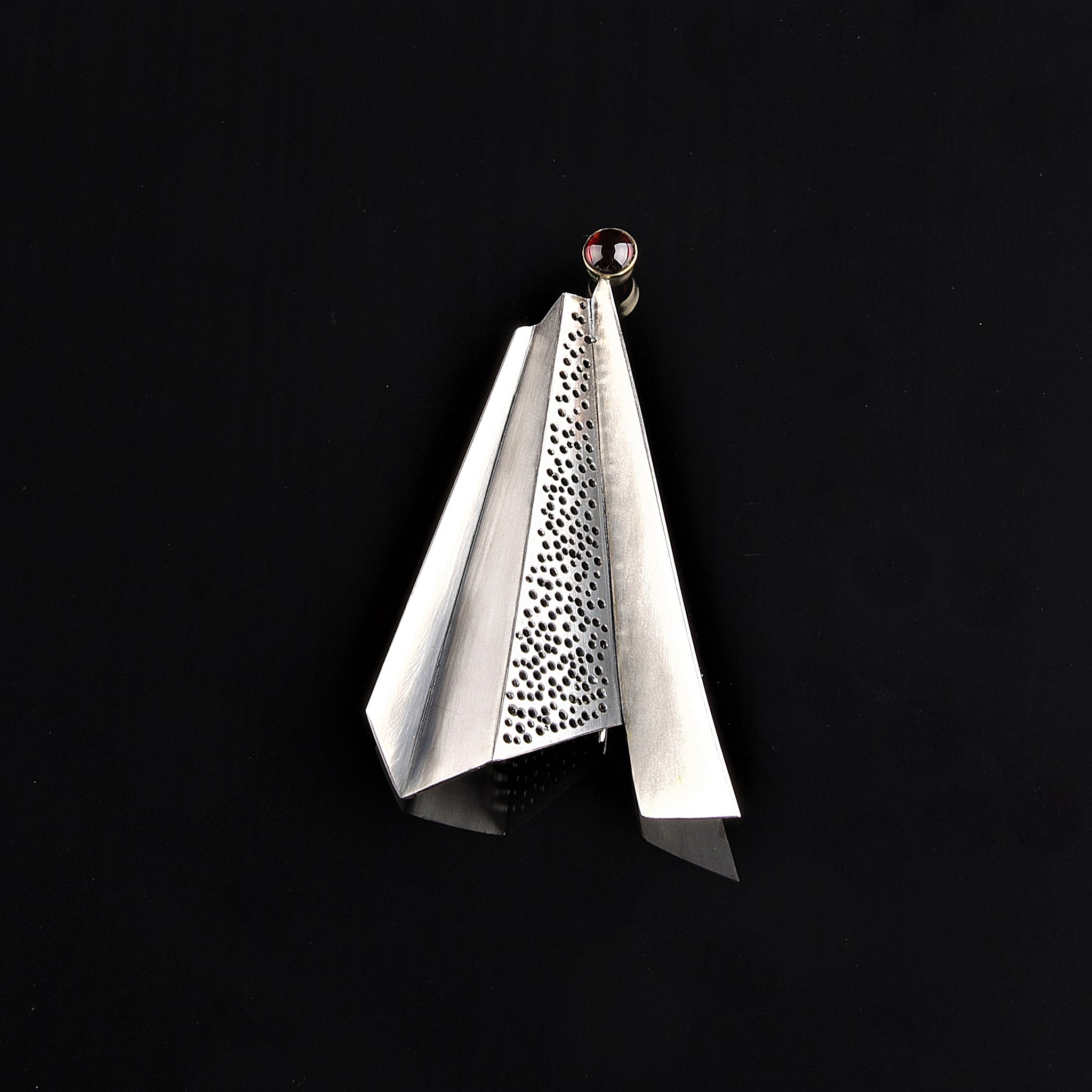 Architectural silver brooch with garnet.